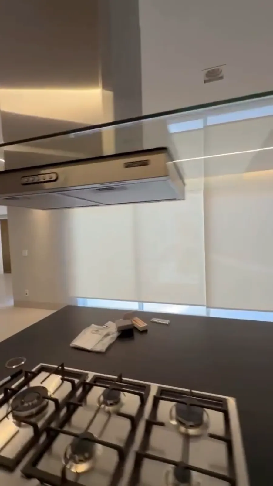 Cozinha com rolô screen na janela atrás do cooktop